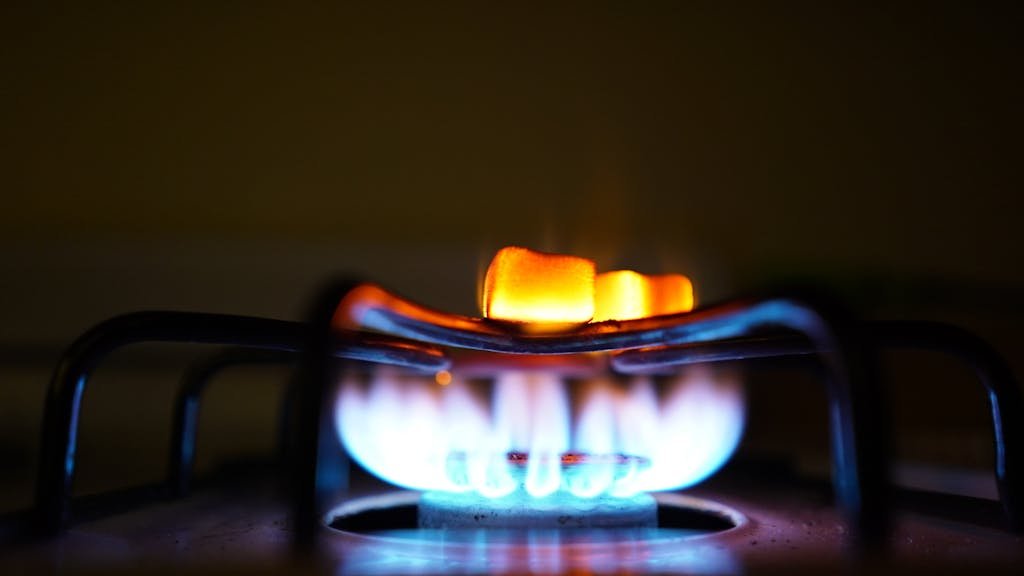 Roasting marshmallows over an indoor gas stove for a cozy treat.